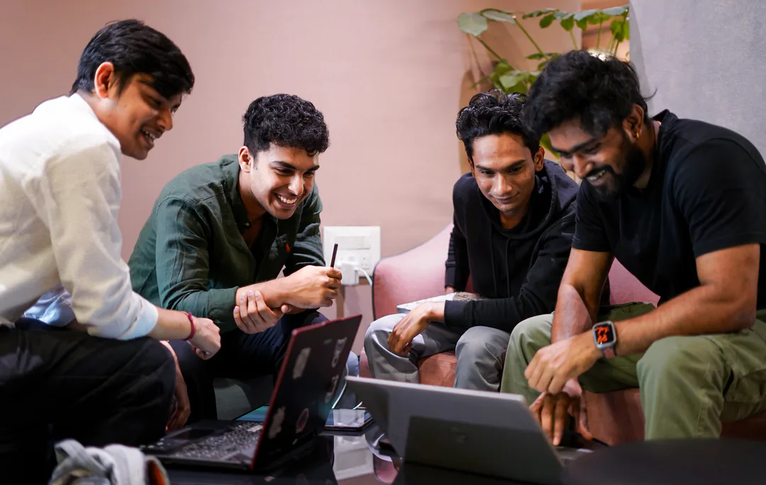 Mentor huddle around a laptop
