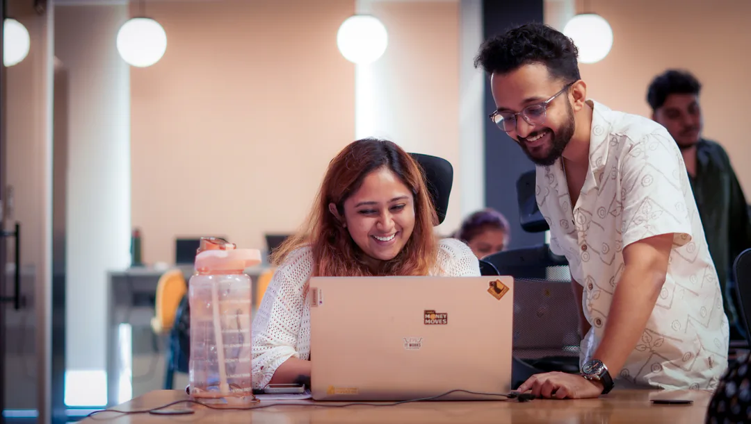 Mentor helping a learner at a laptop